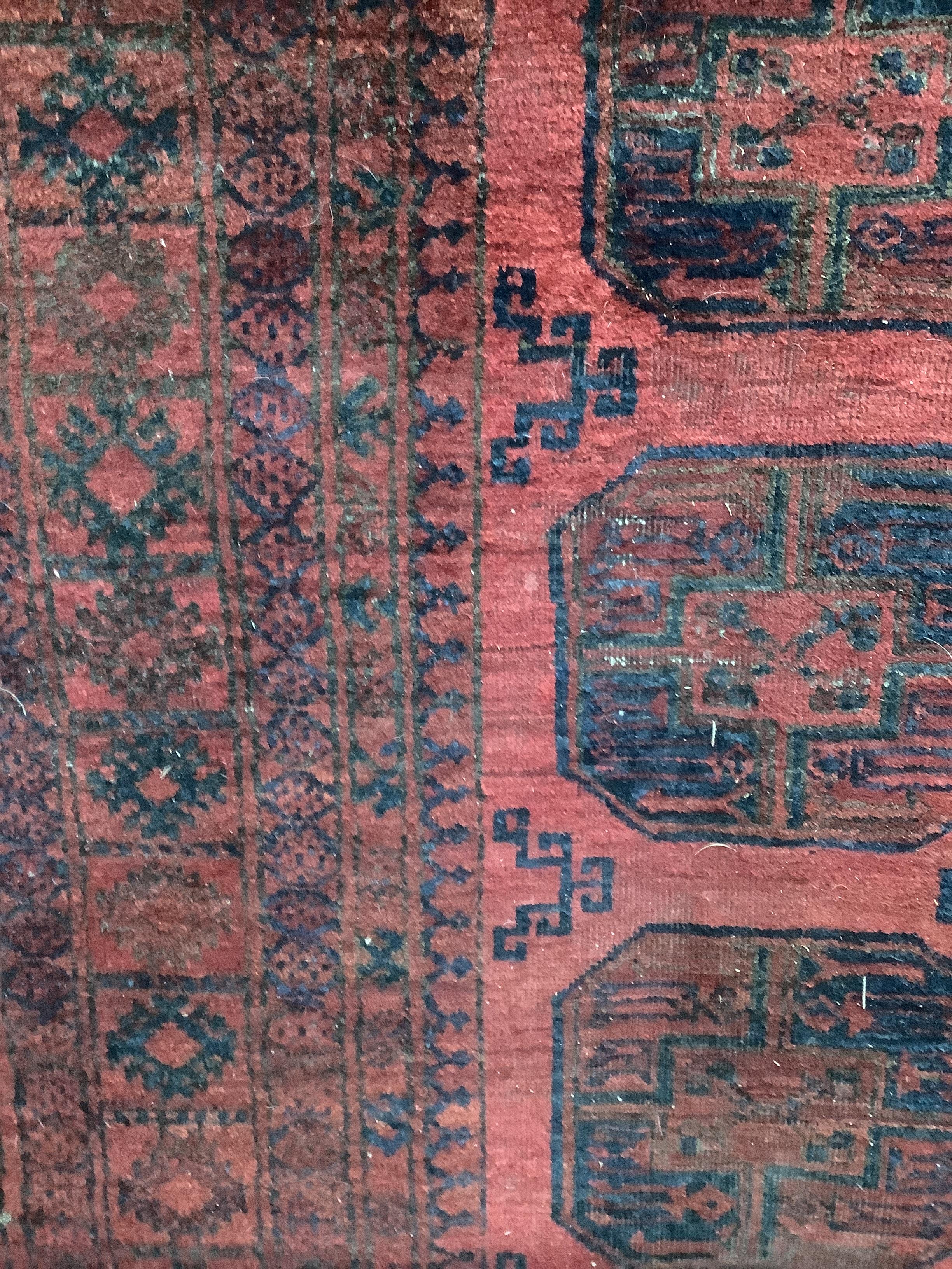 An Afghan red ground carpet, 280 x 206cm